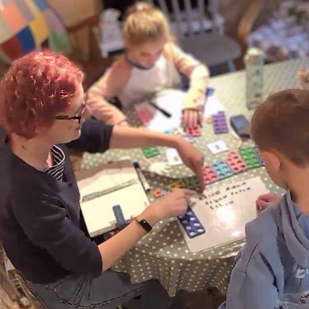 Two children using maths manipulatives with a tutor