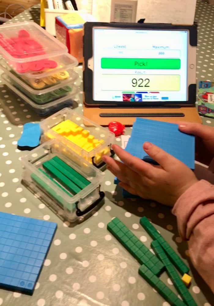 Close up of child's hands busy making 3 digit numbers with base 10 and place value counters